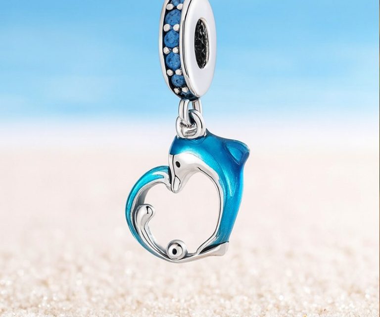 Zilveren hanger in de vorm van een hart met een dolfijn en blauwe accenten.